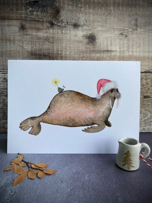 walrus in a christmas hat with a snail on his back greeting card